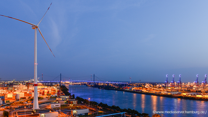 Container-Port-in-Hamburgs-harbor-with-wind-turbine-by-night-