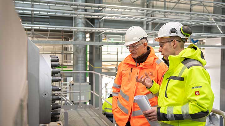 Karl Böhle, Senior Project Manager, MAN Energy Solutions, and Kenneth Jørgensen, Project Director, DIN Forsyning, inside the heat pump hall, Esbjerg, Denmark