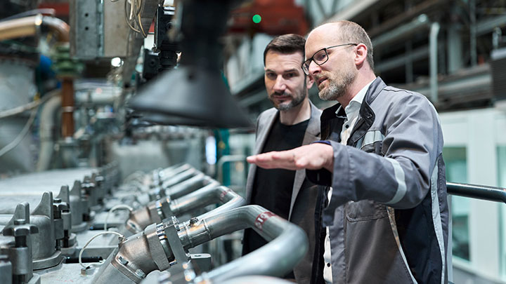 Matthias Auer explaining the methanol engine to a colleague